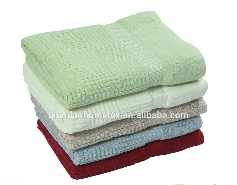 Stack of folded towels in green, white, beige, blue, and red on a plain background, with BSCI and Confidence in Textiles logos below