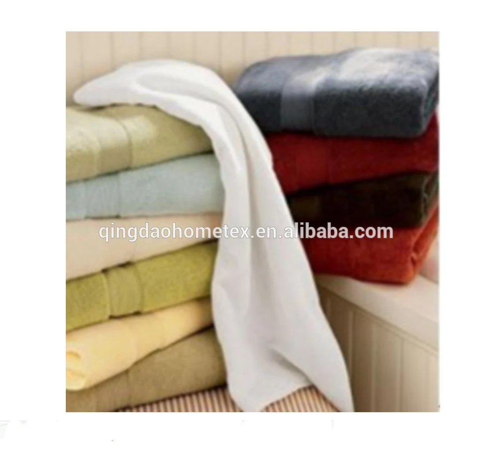 Stacks of folded towels in various colors including white, green, blue, red, and yellow