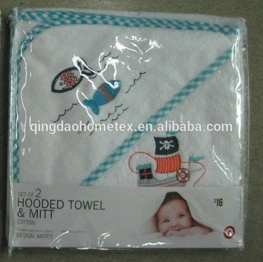 Packaged set of two white hooded baby towels and mitt with blue gingham trim and embroidered fish and pirate boat designs