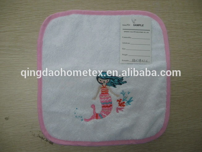 White baby towel with pink border and embroidered mermaid design, with sample tag attached