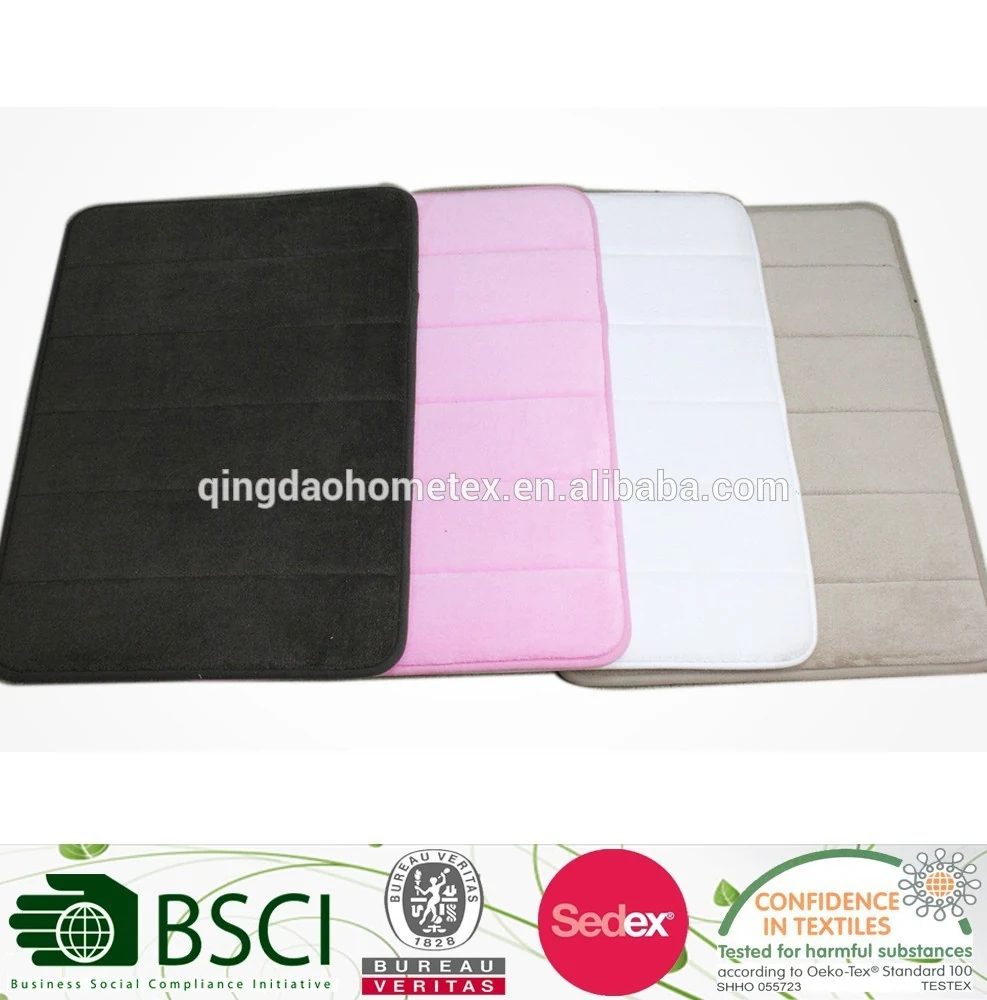 Four memory foam bath mats in black, pink, white, and beige fanned out on a white background