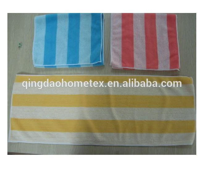 Three striped towels in blue, pink, and yellow laid flat on a wooden surface