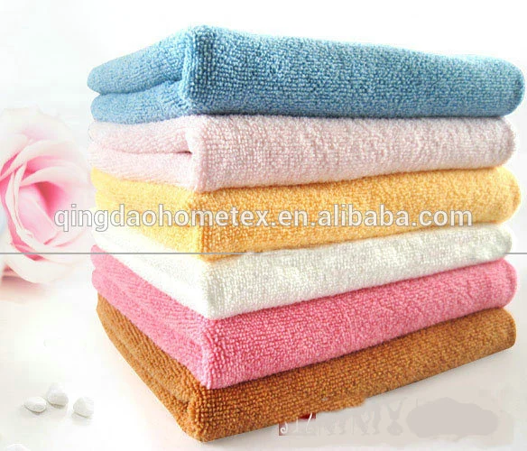 Stack of folded microfiber towels in blue, white, yellow, pink, and brown