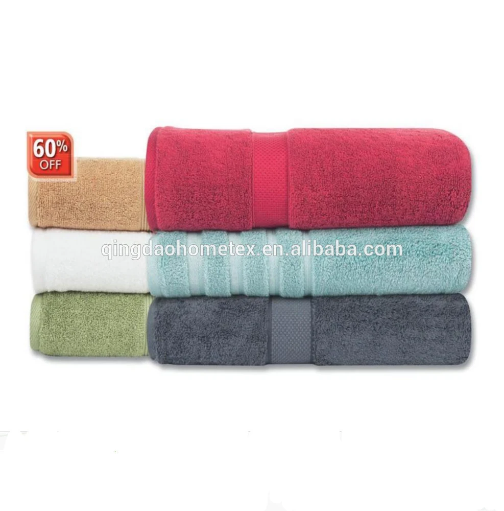 Stack of rolled towels in red, beige, white, teal, green, and dark gray on a white background
