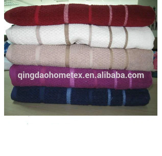 Stack of five folded towels in red, white, beige, magenta, and navy with woven stripes