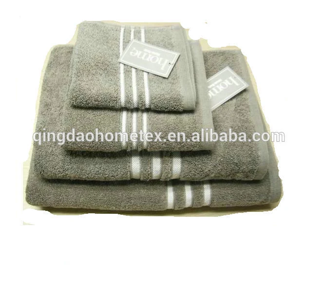 Stack of folded grey towels with white stripes and paper tags