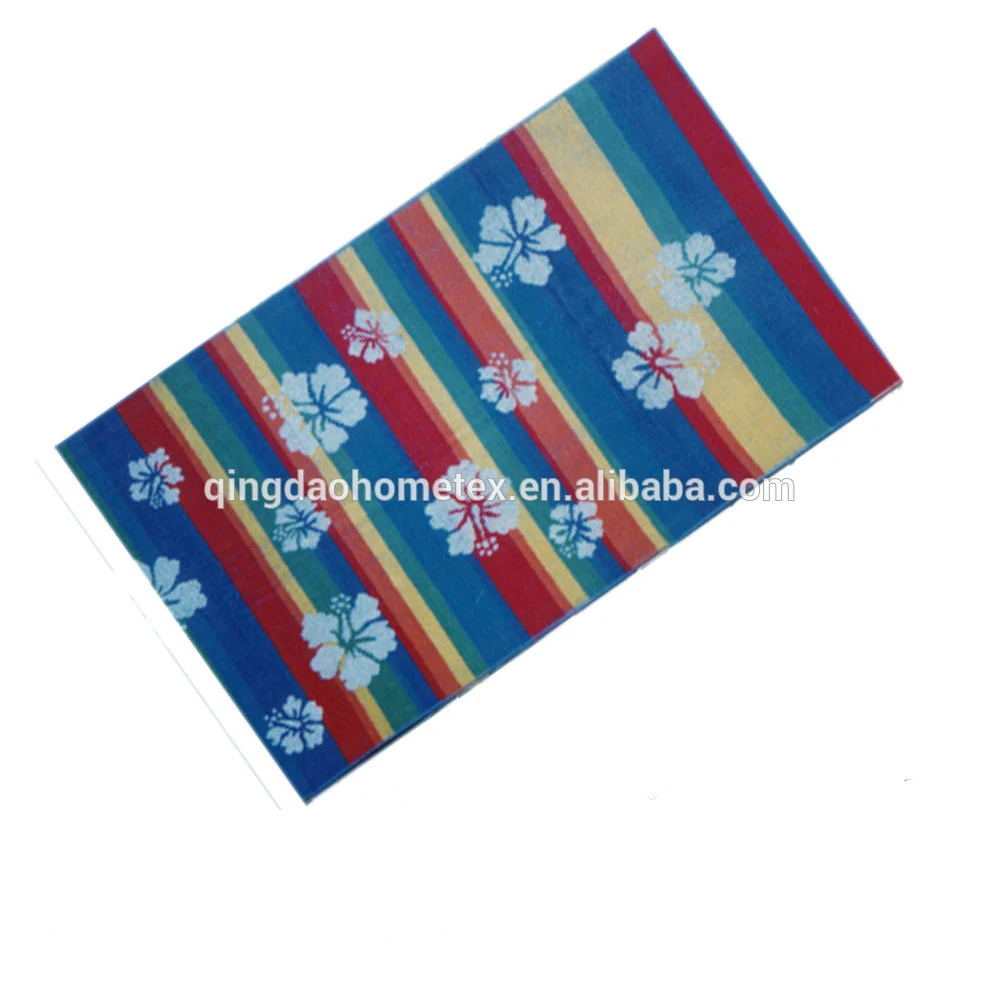Striped beach towel in red, blue, tan and teal with light blue hibiscus flower prints, shown at an angle