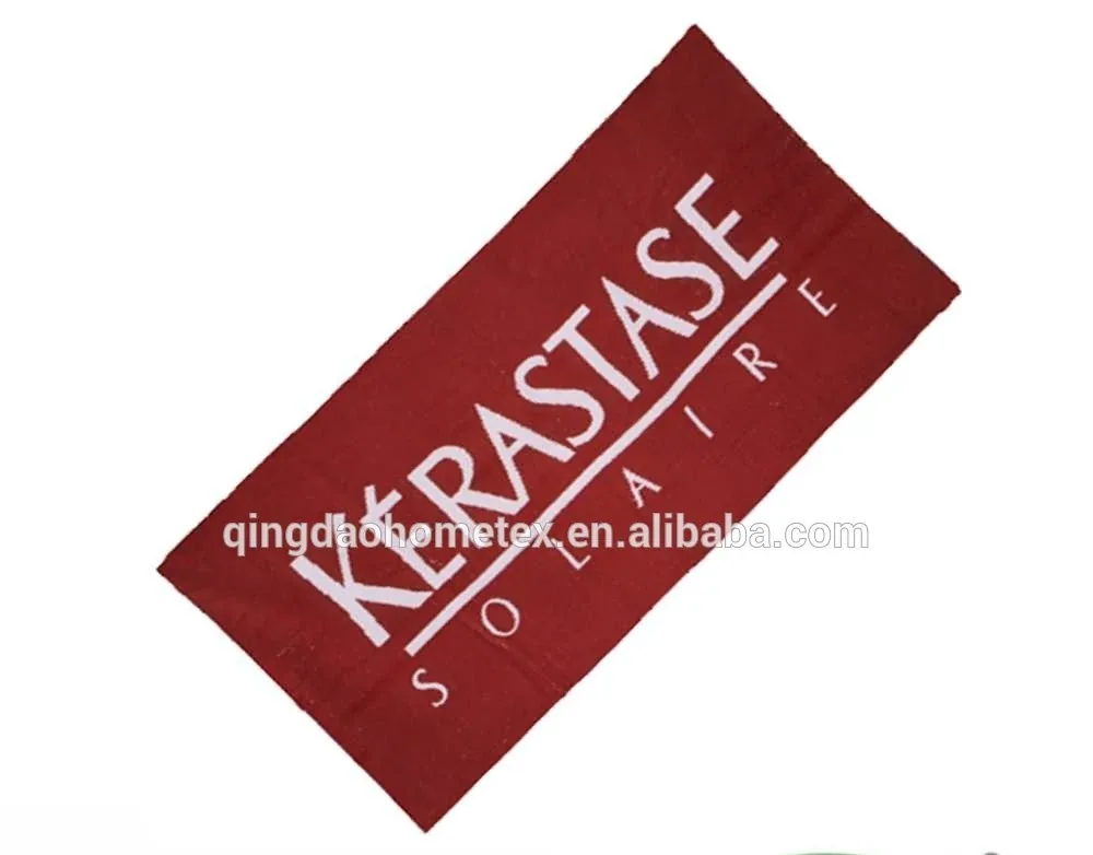 Red beach towel with white Kerastase Solaire branding on white background, with BSCI and Oeko-Tex logos below