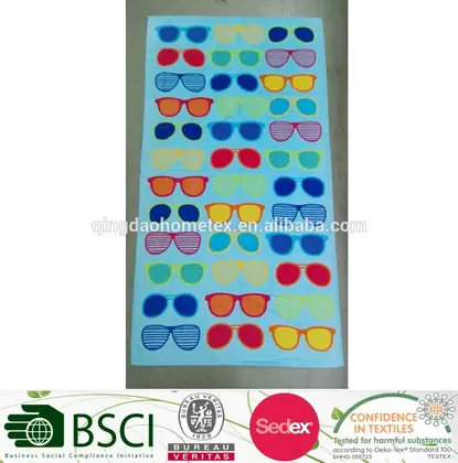 Light blue printed towel with rows of colorful sunglasses patterns, photographed lying flat