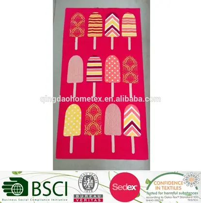 Red beach towel with popsicle pattern, displayed with certification logos