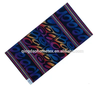Colorful woven jacquard towel with cursive letter pattern in blue, red, purple, and orange, displayed diagonally on white background