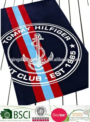 Navy striped beach towel with white anchor emblem; certification logos overlaid at bottom