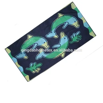 Navy blue beach towel printed with green and blue dolphins and coral motifs on white background
