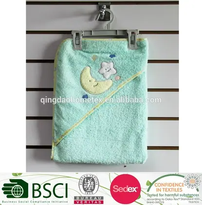 A mint green hooded baby towel with embroidered moon and star hanging on a display rack.