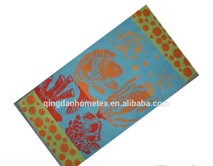 Blue beach towel with orange fish and coral print tilted diagonally, BSCI and Oeko-Tex certification logos overlaid below