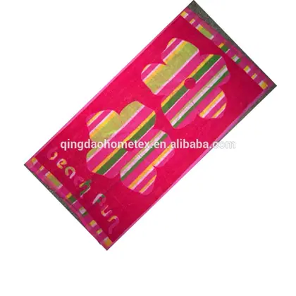 Pink striped beach towel with large flower motif displayed diagonally on white background