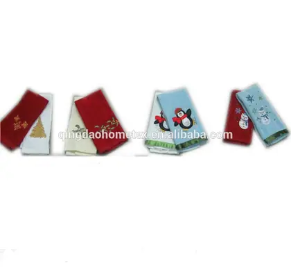 Folded Christmas kitchen towels in red, cream and blue with embroidered tree, snowflake, penguin and snowman designs