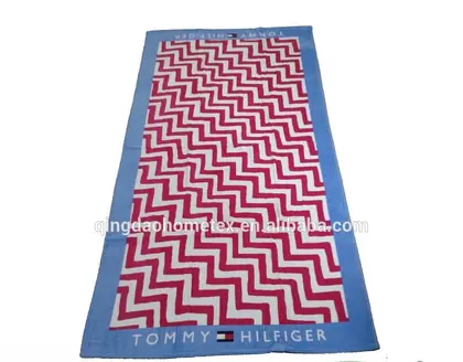 A blue and red chevron patterned towel with certification logos at the bottom.