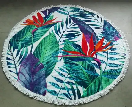 150 cm diameter round 100% cotton beach towel with a green leaves pattern printed on the surface and tassels on the edge, laid flat