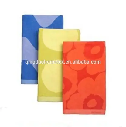 Three folded printed towels in blue, yellow-green, and orange floral patterns on a white background