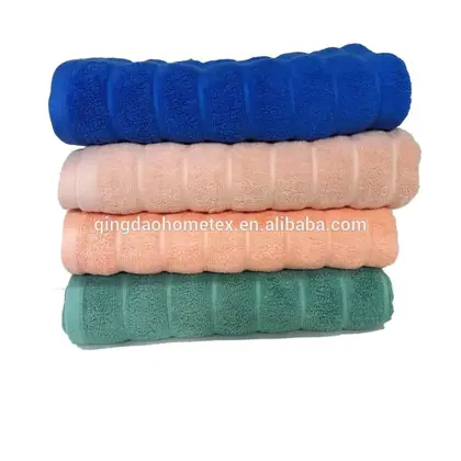 Stack of four folded towels in blue, pink, peach, and green colors on a white background