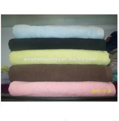 Stack of folded towels in light blue, navy, yellow, brown and pink on a shelf