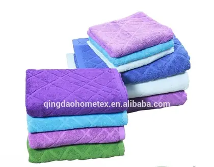 Stacks of folded purple, blue, and green textured towels displayed above certification logos.