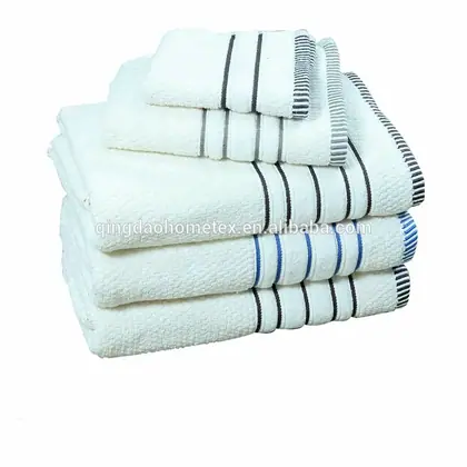 Stack of folded white towels with black, gray, and blue striped borders on white background