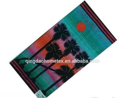 A tropical palm tree towel lying diagonally with certification logos below it.