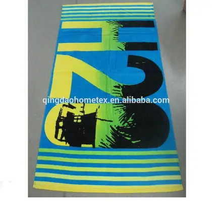 Blue printed beach towel with large H2O design and yellow-green striped borders laid on a gray floor