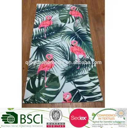 Flamingo and tropical leaf patterned fabric on a wooden floor with certification logos at the bottom.