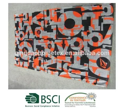 Folded fabric with an abstract orange, black, and grey geometric pattern.