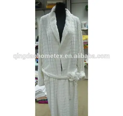 White waffle-weave bathrobe with tie belt displayed on a black mannequin in a cluttered showroom