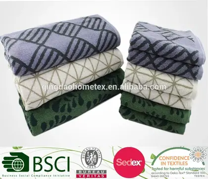 Two stacks of folded patterned towels in blue, cream, and green on a white background