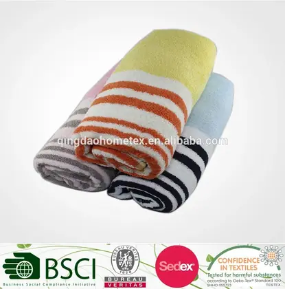 Three rolled striped towels in yellow-orange, gray, and white with black, above a strip of certification logos