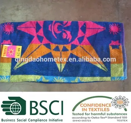 Colorful beach towel with geometric sun design and price tag, displayed with certification logos.