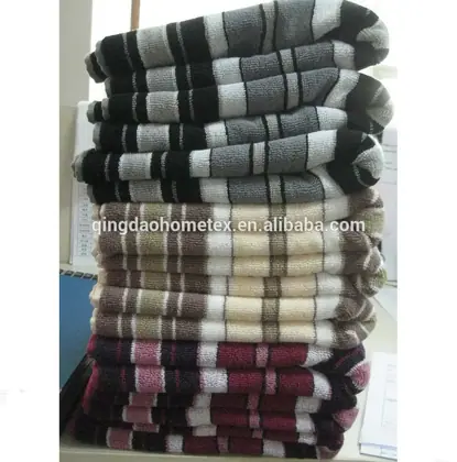 Stack of folded striped towels in gray, beige, and burgundy colors piled on a shelf