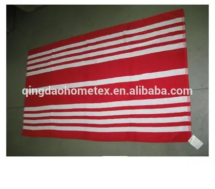 Red beach towel with white horizontal stripes laid flat on a tiled floor