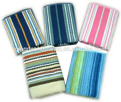 Five folded striped towels in blue, green, pink and multicolor yarn-dyed patterns fanned out on a white background