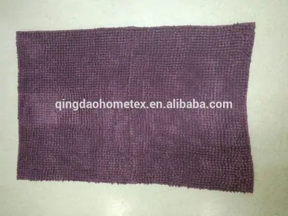 Purple chenille bath mat with nubby textured surface laid flat on a