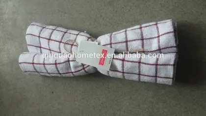 Two folded white towels with a red grid pattern tied together with a string and a tag.