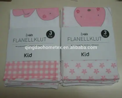 Two stacks of folded pink and white children's flannel cloths with paper packaging bands on a plain surface.