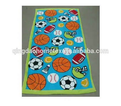 Printed beach towel with green border featuring sports ball patterns including basketballs, soccer balls, and footballs on blue background