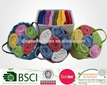 Rolled colorful towels in baskets and a box, with certification logos banner below