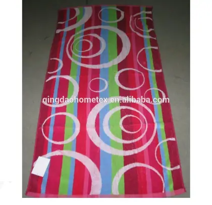 Colorful striped beach towel with white circle patterns in pink, green, and blue, laid flat