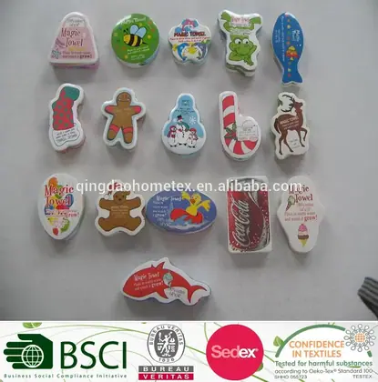 Assorted compressed towels in novelty shapes, including gingerbread man, candy cane, fish, and bear, on a white surface