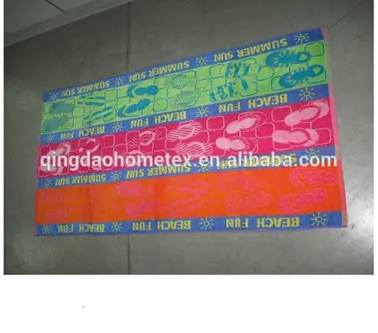 Colorful printed beach towels with 'SUMMER SUN' and 'BEACH FUN' designs laid on a tiled floor