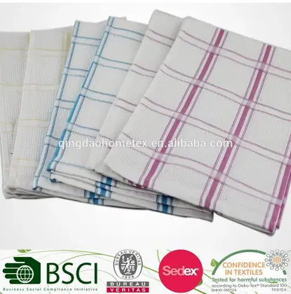 Stack of woven check-pattern kitchen towels in yellow, blue, and purple, with certification logos overlaid at the bottom