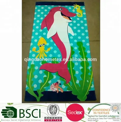 Colorful beach towel with printed pink dolphin, yellow octopus, seahorse and seaweed on a turquoise polka-dot background