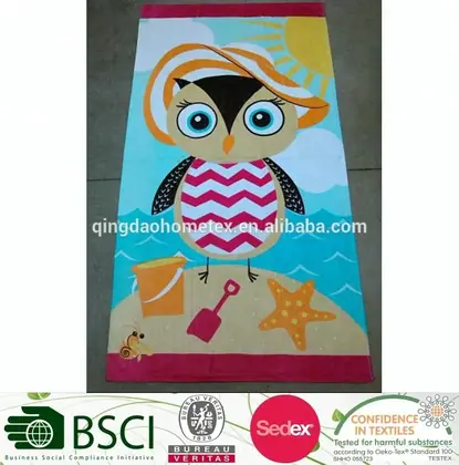 Beach towel with printed cartoon owl wearing a sun hat, with bucket, spade and starfish on a sandy shore design